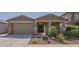 Charming home featuring a two-car garage, a covered front porch and manicured landscaping at 18187 W Via Montoya Dr, Surprise, AZ 85387