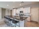 Modern kitchen featuring an island with barstools, white cabinets and subway tile backsplash at 18187 W Via Montoya Dr, Surprise, AZ 85387