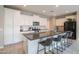 Modern kitchen featuring white cabinets, stainless steel appliances, large island with seating and decor at 18187 W Via Montoya Dr, Surprise, AZ 85387
