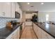 Bright kitchen features white cabinets, dark countertops, stainless steel appliances, and a large island at 18187 W Via Montoya Dr, Surprise, AZ 85387