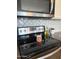 Modern black cooktop with stainless steel appliances, and white backsplash at 18187 W Via Montoya Dr, Surprise, AZ 85387