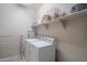 Practical laundry room with white washer and dryer, shelving, and hanging rack at 18187 W Via Montoya Dr, Surprise, AZ 85387