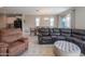 Comfortable living room showcasing a sectional sofa, recliner, area rug, and bright natural light at 18187 W Via Montoya Dr, Surprise, AZ 85387