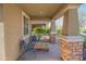 Covered front porch with stone accents and outdoor seating. Two chairs with a table at 18187 W Via Montoya Dr, Surprise, AZ 85387