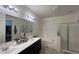 Bright bathroom with a double sink vanity, a soaking tub, and a separate glass-enclosed shower at 18542 W Luke Ave, Litchfield Park, AZ 85340