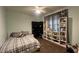 Spacious bedroom with a comfy bed, ceiling fan, and shelving unit for decor and storage at 18542 W Luke Ave, Litchfield Park, AZ 85340