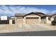 Home exterior featuring a spacious three car garage and a well-maintained desert landscaped yard at 18542 W Luke Ave, Litchfield Park, AZ 85340