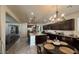 Well-lit kitchen with stainless steel appliances, large island, and dark cabinets leading into the living room at 18542 W Luke Ave, Litchfield Park, AZ 85340