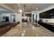 Wide shot of the kitchen, showing an island with seating, stainless steel appliances, and dark cabinets at 18542 W Luke Ave, Litchfield Park, AZ 85340