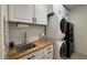 Functional laundry room with white cabinets, a butcher block countertop, and a stackable washer/dryer at 18542 W Luke Ave, Litchfield Park, AZ 85340