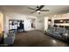 Inviting living room featuring carpet flooring, ceiling fan, and seamless flow into the kitchen area at 18542 W Luke Ave, Litchfield Park, AZ 85340