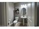 Charming powder room with a pedestal sink, modern lighting, and stylish decor at 18542 W Luke Ave, Litchfield Park, AZ 85340