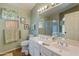 Bathroom featuring a double sink vanity, toilet, glass-enclosed shower, and decorative elements at 18886 N 77Th Ave, Glendale, AZ 85308