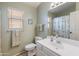 Bathroom featuring a single sink vanity, toilet, window, and shower/tub combo with a floral-themed curtain at 18886 N 77Th Ave, Glendale, AZ 85308
