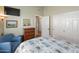 Bedroom with patterned bedding, closet, and a cozy armchair at 18886 N 77Th Ave, Glendale, AZ 85308