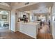 Open kitchen area with white cabinets, stainless steel sink, black appliances, and breakfast bar at 18886 N 77Th Ave, Glendale, AZ 85308