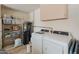 Functional laundry room with modern washer, dryer, storage shelves and cabinet at 18886 N 77Th Ave, Glendale, AZ 85308