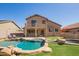 Spacious backyard featuring a unique pool design, covered patio, and manicured lawn at 22236 N 48Th St, Phoenix, AZ 85054
