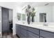 Stylish bathroom features double sinks, decorative gray cabinetry, and a large mirror at 22236 N 48Th St, Phoenix, AZ 85054