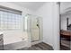 Bright bathroom featuring glass block window, glass enclosed shower and soaking tub at 22236 N 48Th St, Phoenix, AZ 85054