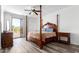 Serene main bedroom featuring wood floors, a four poster bed, ceiling fan, and access to private balcony at 22236 N 48Th St, Phoenix, AZ 85054