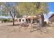 Charming backyard featuring a covered patio, desert plants, and a peaceful outdoor setting at 2453 E Hancock Trl, Casa Grande, AZ 85194