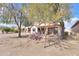 Serene backyard with covered patio, desert plants, and space for outdoor entertaining at 2453 E Hancock Trl, Casa Grande, AZ 85194