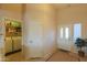 Hallway with a laundry area on the left and a glass front door leading to the front porch at 2453 E Hancock Trl, Casa Grande, AZ 85194