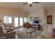 The living room has a ceiling fan, a glass coffee table, and sliding door access to the exterior at 2453 E Hancock Trl, Casa Grande, AZ 85194