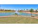 Picturesque view of a community pond with fountain, lush greenery, and residential homes at 2453 E Hancock Trl, Casa Grande, AZ 85194
