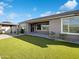 Lush backyard featuring artificial grass, a covered patio, and outdoor seating on a sunny day at 2526 E Novak Way, Phoenix, AZ 85042