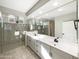 Bathroom featuring double sinks, a large framed mirror and glass enclosed shower at 2526 E Novak Way, Phoenix, AZ 85042