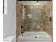 A bathroom featuring a glass door shower over tub, with decorative tile accent and rainfall shower head at 27708 N 110Th Pl, Scottsdale, AZ 85262