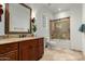 Elegant bathroom with granite countertop vanity, framed mirror and a shower-over-tub combo with glass doors at 27708 N 110Th Pl, Scottsdale, AZ 85262