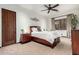 Cozy bedroom featuring a ceiling fan, an accent wall hanging, a wood-frame window and matching dressers at 27708 N 110Th Pl, Scottsdale, AZ 85262