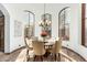 An elegant dining room offers ample light from arched windows and a traditional chandelier at 27708 N 110Th Pl, Scottsdale, AZ 85262