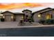 Home exterior showcasing a three-car garage, stone accents, desert landscaping, and a charming front entrance at 27708 N 110Th Pl, Scottsdale, AZ 85262