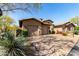 Exterior view of a home featuring a well-manicured yard, desert landscaping, and three-car garage at 27708 N 110Th Pl, Scottsdale, AZ 85262