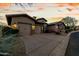 Stunning home exterior showing a well-manicured lawn and an attached three-car garage with stone veneer accents at 27708 N 110Th Pl, Scottsdale, AZ 85262