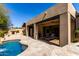 Exterior view of the home with a pool, patio area, and outdoor fireplace at 27708 N 110Th Pl, Scottsdale, AZ 85262
