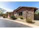 Exterior view showing stonework, desert landscaping, and a lush yard at 27708 N 110Th Pl, Scottsdale, AZ 85262