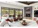 Living room featuring sliding glass doors, a stone fireplace, modern furnishings, and an open layout at 27708 N 110Th Pl, Scottsdale, AZ 85262