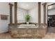 Main bathroom highlighting the tiled soaking tub framed by decorative columns and view to the walk-in closet at 27708 N 110Th Pl, Scottsdale, AZ 85262