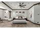 Open main bedroom boasts a ceiling fan, decorative columns, soft carpet, and an abundance of natural light at 27708 N 110Th Pl, Scottsdale, AZ 85262
