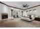 Large main bedroom with a fireplace, sitting area beneath an archway, ceiling fan, and neutral-toned carpet at 27708 N 110Th Pl, Scottsdale, AZ 85262