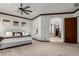 Spacious main bedroom with en suite access, ceiling fan, carpet floors, and elegant dark wood trim accents at 27708 N 110Th Pl, Scottsdale, AZ 85262