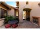 Outdoor patio area featuring brick flooring, a fireplace, dining area, and lush desert landscaping at 27708 N 110Th Pl, Scottsdale, AZ 85262