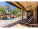 A covered patio with lounge chairs overlooks a water feature in the pool area at 27708 N 110Th Pl, Scottsdale, AZ 85262