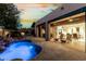 Inviting backyard pool and patio with rock waterfall feature, fireplace, lounge seating, and seamless indoor/outdoor living at 27708 N 110Th Pl, Scottsdale, AZ 85262