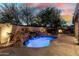 Outdoor living space with a pool, waterfall feature and exterior fireplace at 27708 N 110Th Pl, Scottsdale, AZ 85262